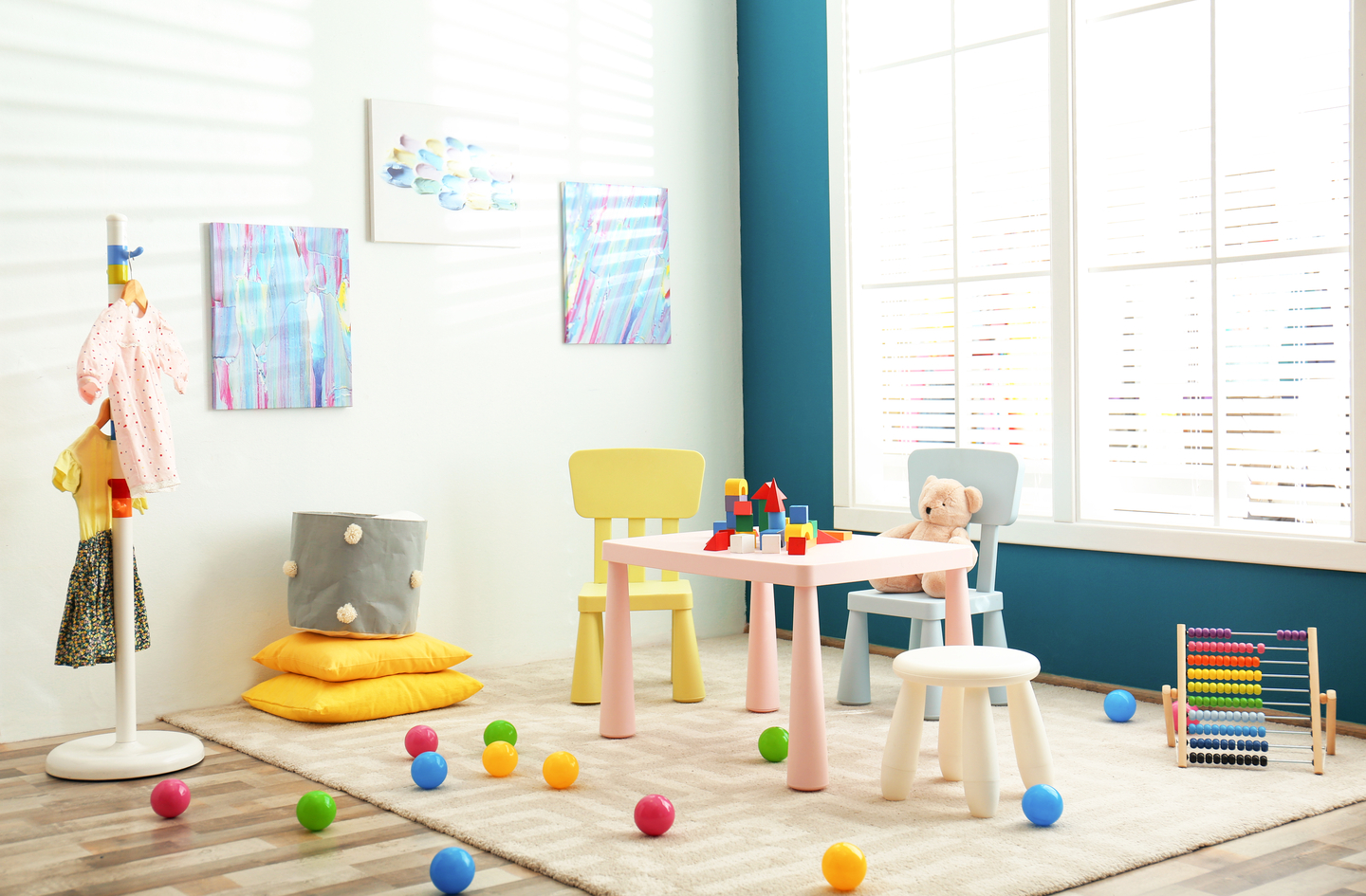 A brightly lit children's playroom with scattered plastic balls on a soft rug showing an open floor zone for gross motor play